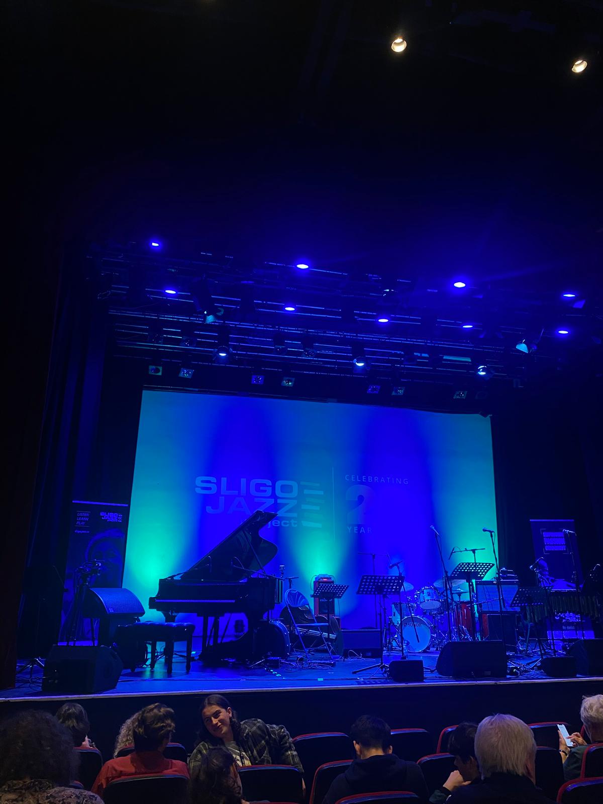 Sligo Jazz Project stage with grand piano under blue and green lighting